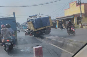 Truk Naik Pembatas Jalan