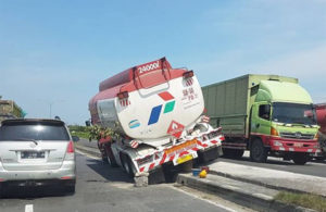 Truk Tangki Naik ke Pembatas Jalan