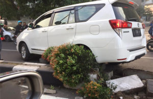 Mobil Tabrak dan Naik Pembatas Jalan