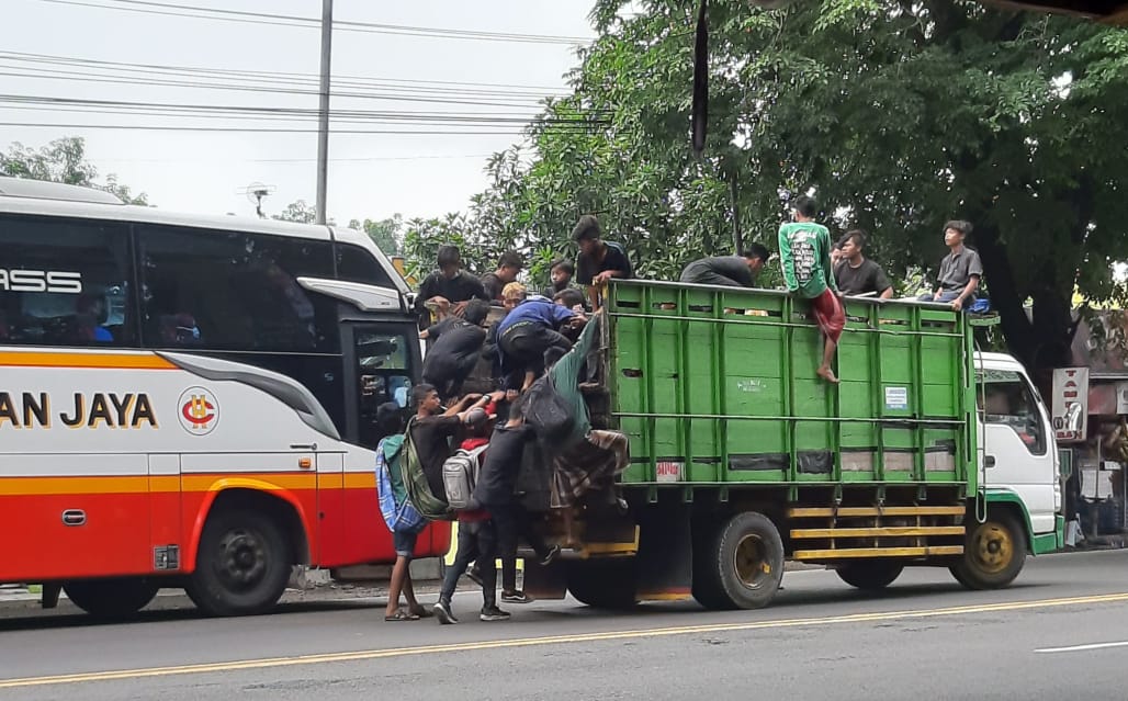 Berniat menumpang, beberapa anak memberhentikan Truk yang sedang melaju. Lalu naik ke bagian bak Truk yang kosong. Lokasi di Bakalan Balongbendo, Sabtu (23/1) siang