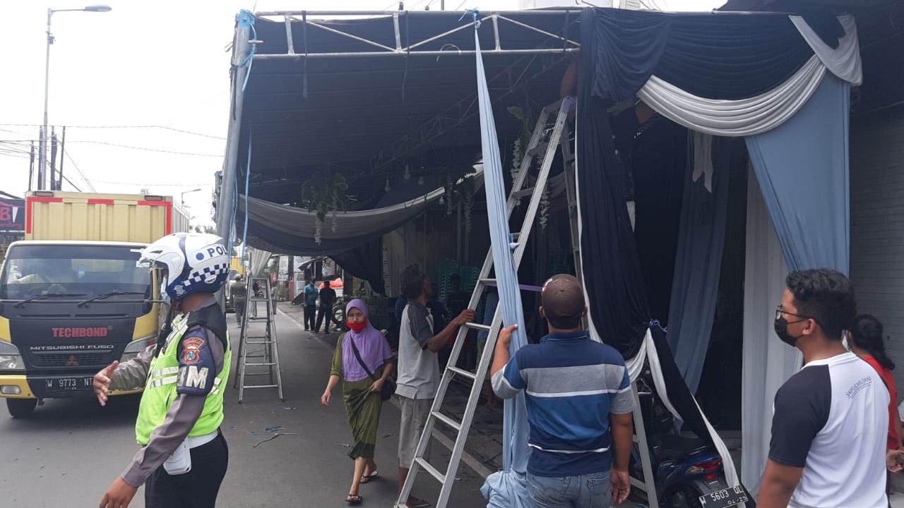 Tenda hajatan warga yang mengganggu lalu lintas di Betro, dibongkar oleh polisi, Jumat (8/1) pagi. Menurut Iptu Cholil Kasubnit 1 Lantas Polresta Sidoarjo, tenda akan sedikit dimundurkan agar tidak mengganggu jalan.