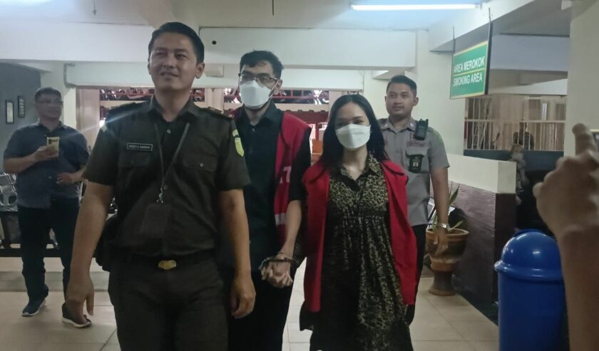 Dua terdakwa pemeran video porno kebaya merah bergandengan tangan saat akan menjalani sidang putusan di PN Surabaya, Selasa (29/8/2023). Foto: Meilita suarasurabaya.net