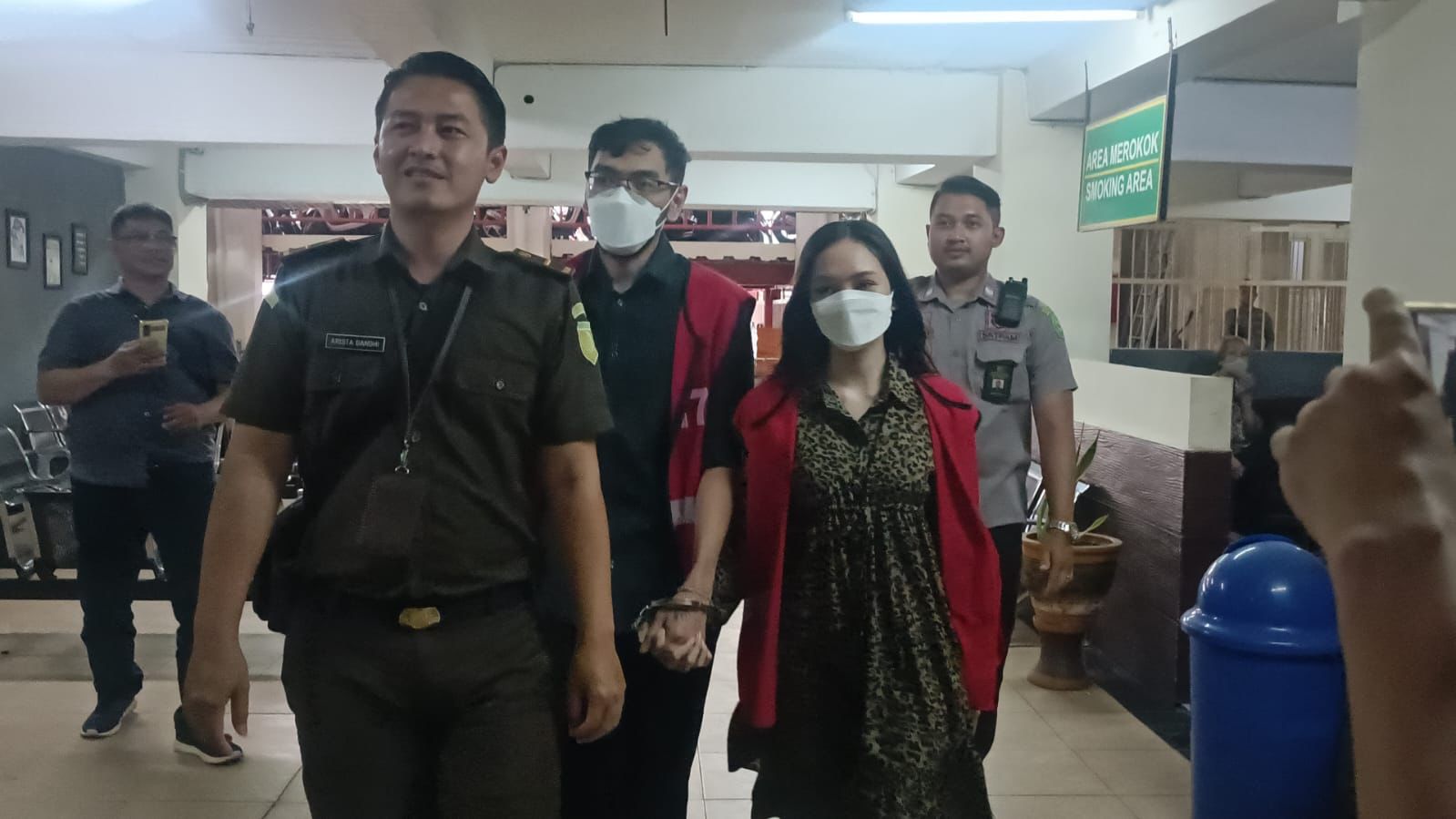 Dua terdakwa pemeran video porno kebaya merah bergandengan tangan saat akan menjalani sidang putusan di PN Surabaya, Selasa (29/8/2023). Foto: Meilita suarasurabaya.net