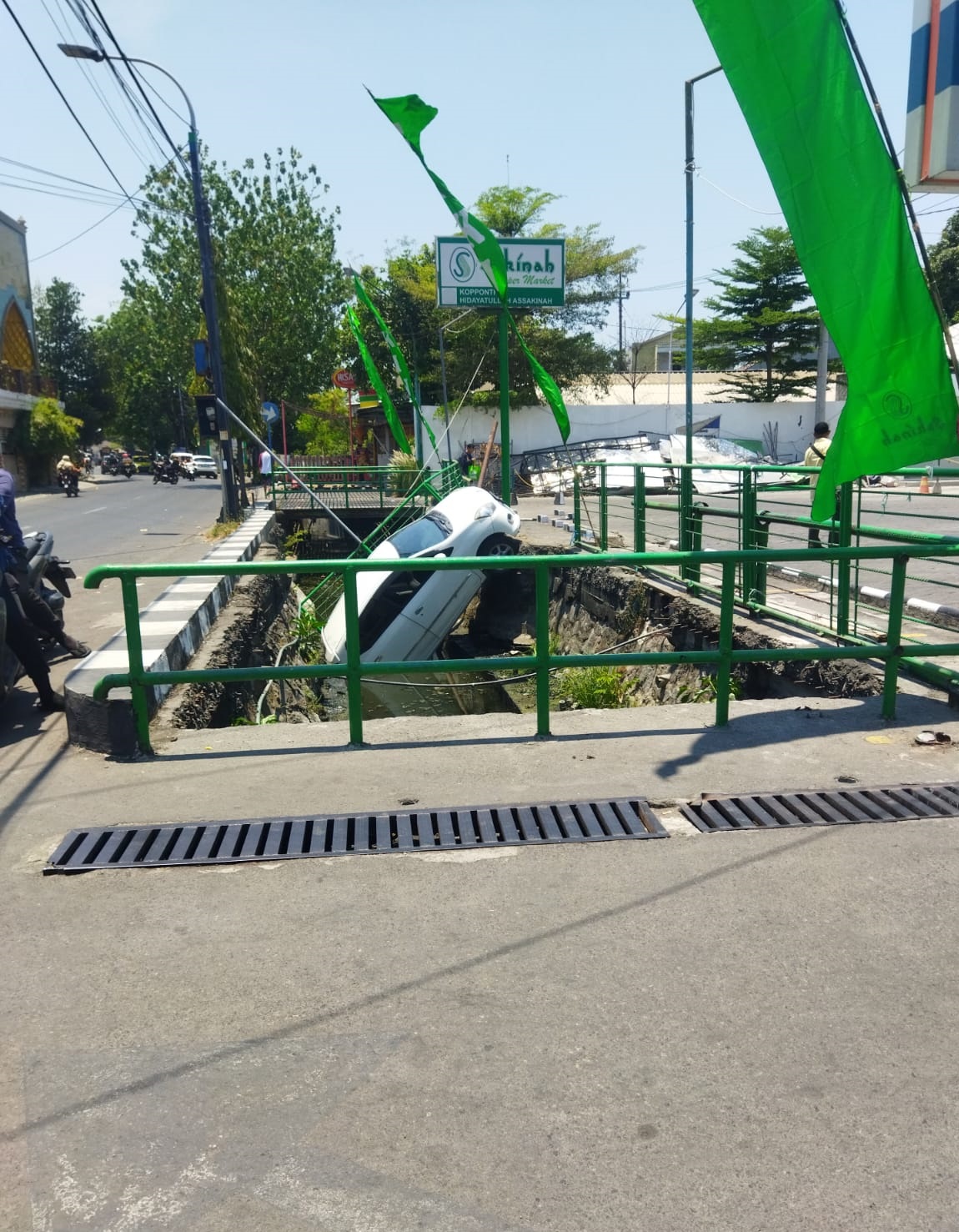 Mobil terperosok di parit di depan supermarket di Jl Arief Rahman Hakim Surabaya, Kamis (28/9/2023) siang.