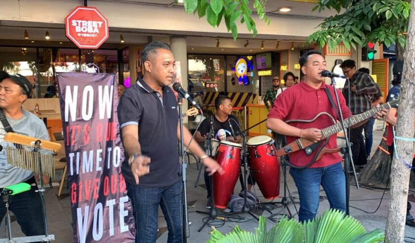 Musisi yang tergabung dengan relawan Ganjar Pranowo sedang bermain musik di Jalan Tunjungan Surabaya tepat di seberang Hotel Majapahit lokasi berlangsungnya deklarasi Anies-Cak Imin, Sabtu (2/9/2023). Foto: Wildan suarasurabaya.net