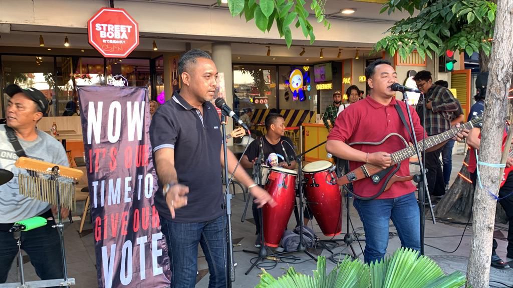 Musisi yang tergabung dengan relawan Ganjar Pranowo sedang bermain musik di Jalan Tunjungan Surabaya tepat di seberang Hotel Majapahit lokasi berlangsungnya deklarasi Anies-Cak Imin, Sabtu (2/9/2023). Foto: Wildan suarasurabaya.net