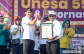 Nurhasan Rektor Universitas Negeri Surabaya (Unesa) saat menerima penghargaan rekor MURI pemakaian sepatu beda warna dalam jalan sehat di Unesa Lidah, Sabtu (9/9/2023). Foto: Unesa