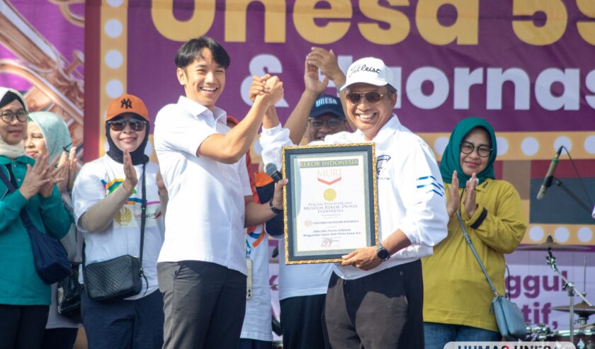 Nurhasan Rektor Universitas Negeri Surabaya (Unesa) saat menerima penghargaan rekor MURI pemakaian sepatu beda warna dalam jalan sehat di Unesa Lidah, Sabtu (9/9/2023). Foto: Unesa
