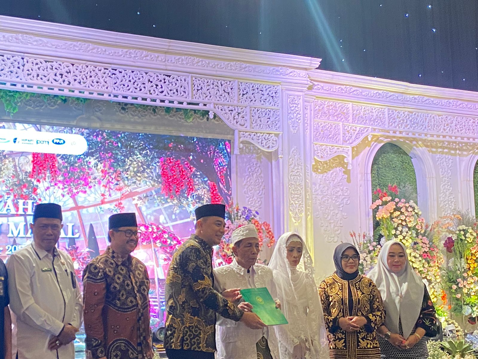 Eri Cahyadi Wali Kota Surabaya menyerahkan dokumen pencatatan nikah pasutri lansia tertua di isbat nikah massal, Selasa (19/9/2023). Foto: Meilita suarasurabaya.net