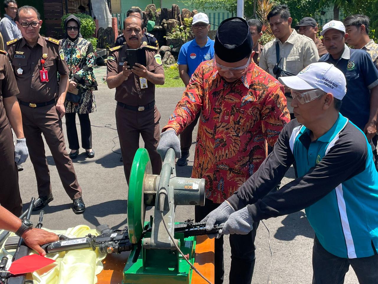 Ahmad Muhdlor Ali Bupati Sidoarjo waktu memotong senpi rakitan di halaman Kejari Sidoarjo, Selasa (26/9/2023). Foto: Wildan suarasurabaya.net
