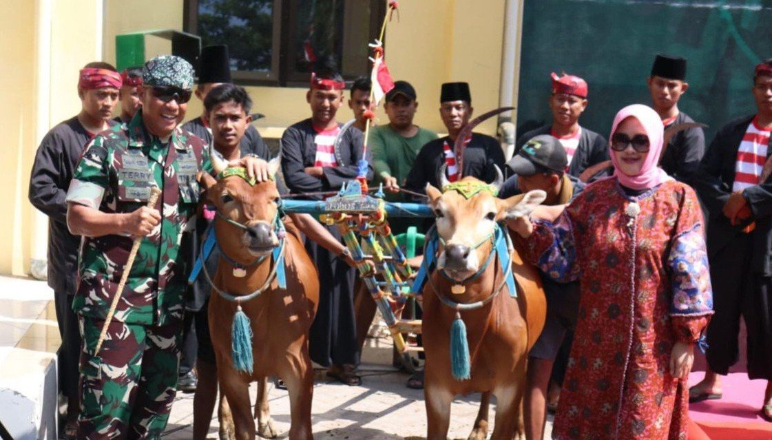 Prajurit TNI berfoto dengan salah satu pasangan sapi peserta lomba karapan sapi di Bangkalan, Jawa Timur, Sabtu (2/9/2023). Foto: Pemkab Bangkalan