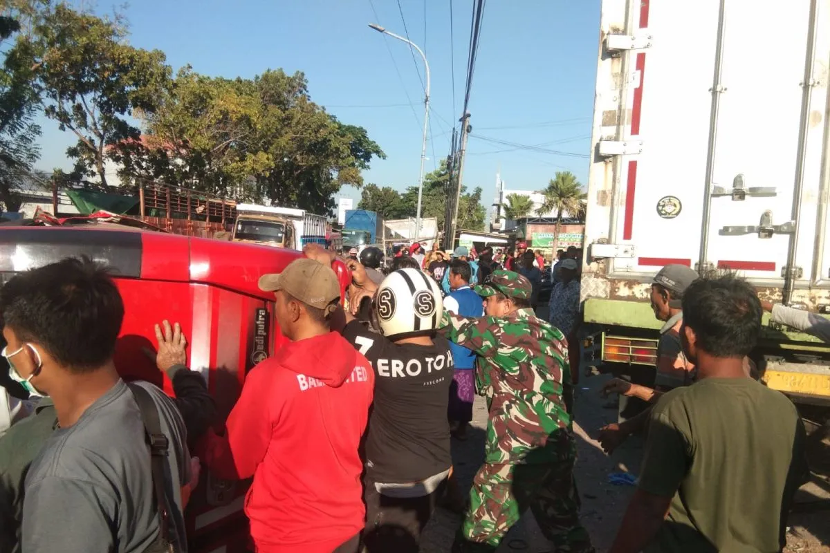 Petugas kepolisian dan TNI serta warga bergotong royong evakuasi microbus yang terguling di jalan raya pantura Kecamatan Besuki, Situbondo, Jawa Timur. Sabtu (23/9/2023). Foto: Antara/Istimewa