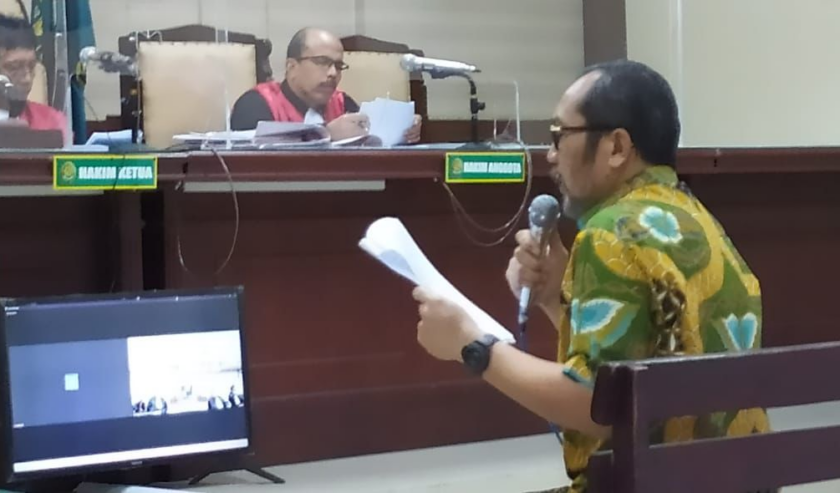 Sahat Tua Simanjuntak, wakil ketua DPRD Jatim nonaktif, mengenakan kemeja batik warna kuning (kiri) saat membacakan pledoi di PN Tipikor Surabaya, Jumat (15/9/2023). Foto: Wildan suarasurabaya.net