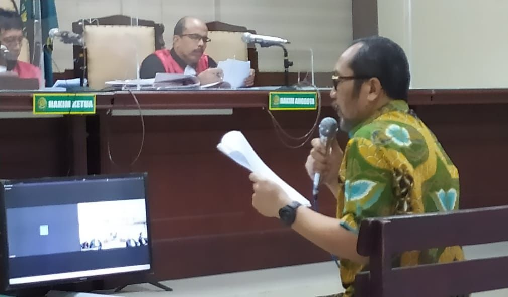 Sahat Tua Simanjuntak, wakil ketua DPRD Jatim nonaktif, mengenakan kemeja batik warna kuning (kiri) saat membacakan pledoi di PN Tipikor Surabaya, Jumat (15/9/2023). Foto: Wildan suarasurabaya.net