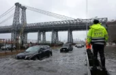 Seorang polisi Patroli Jalan Raya NYPD mengamati para pengendara yang sedang menembus banjir di jalanan FDR Drive di Manhattan dekat jembatan Williamsburg di New York City, Amerika Serikat, pada Jumat (29/9/2023). Foto: Antara/Reuters