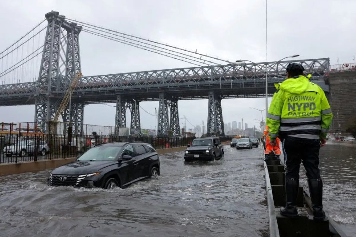 Seorang polisi Patroli Jalan Raya NYPD mengamati para pengendara yang sedang menembus banjir di jalanan FDR Drive di Manhattan dekat jembatan Williamsburg di New York City, Amerika Serikat, pada Jumat (29/9/2023). Foto: Antara/Reuters