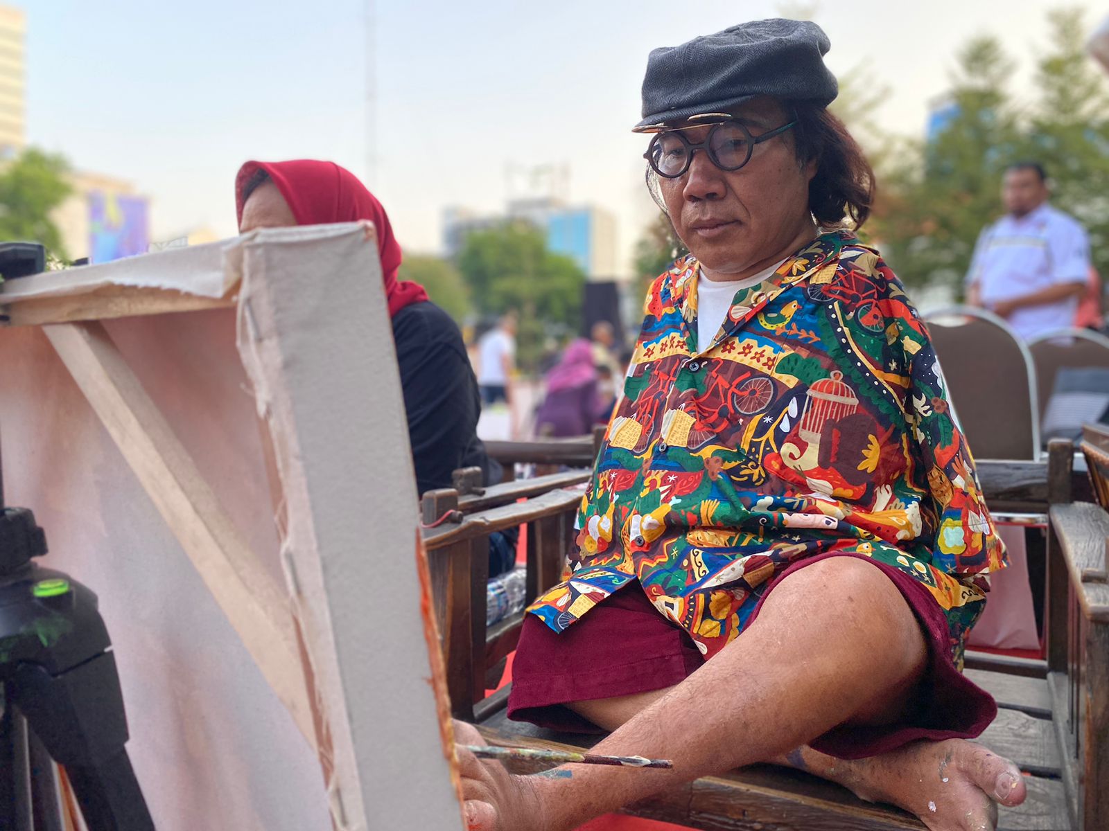 Sadikin Pard salah satu pelukis difabel saat melukis objek dimomen pembukaan Festival Seni Balai Pemuda Surabaya, Jumat (6/10/2023). Foto: Meilita suarasurabaya.net