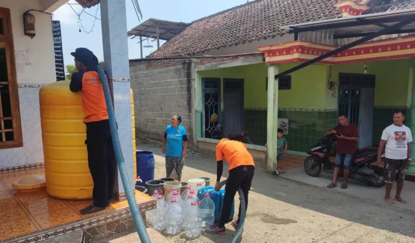 Petugas menyalurkan bantuan air bersih ke rumah-rumah warga di daerah yang cenderung kering dan tandus, di Tulungagung selatan. Foto: BPBD Tulungagung