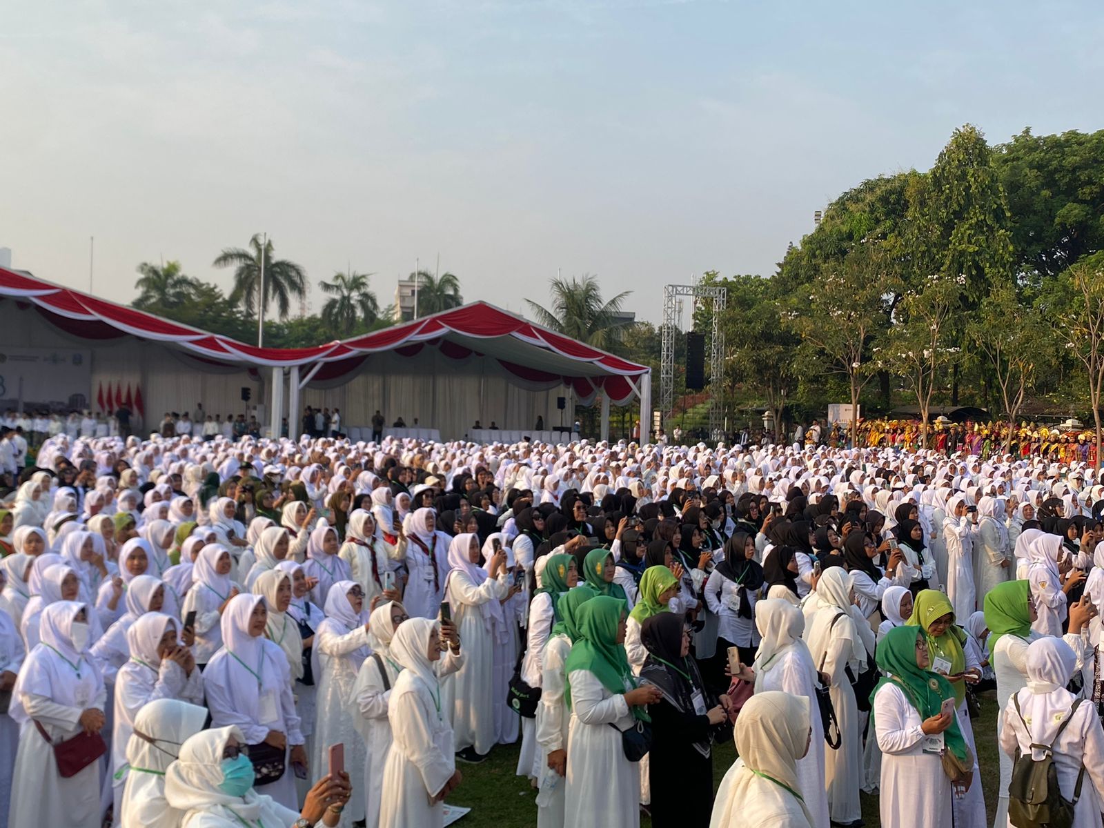 Ribuan santri memotret kehadiran Joko Widodo Presiden RI dan Iriana Ibu Negara yang terpantau layar, Minggu (22/10/2023). Foto: Meilita suarasurabaya.net