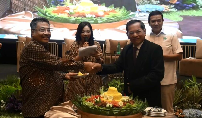 Wahyudi Utomo, ketua panitia HUT ke-42 Mappi menyerahkan potongan tumpeng kepada Muhammad Adil Muttaqin Ketua Umum DPN MAPPI di Whiz Luxe Hotel Surabaya pada Sabtu (21/10/2023). Foto: MAPPI