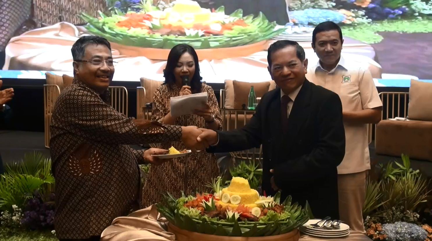 Wahyudi Utomo, ketua panitia HUT ke-42 Mappi menyerahkan potongan tumpeng kepada Muhammad Adil Muttaqin Ketua Umum DPN MAPPI di Whiz Luxe Hotel Surabaya pada Sabtu (21/10/2023). Foto: MAPPI