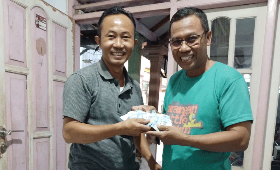 Supriyadi (kiri) menyerahkan amplop yang dia temukan kepada Sumarto (kanan), karyawan Primkopal RSPAL dr. Ramelan Surabaya, Selasa (31/10/2023). Foto: Istimewa