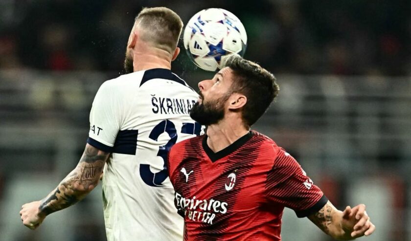 Penyerang AC Milan Olivier Giroud (kanan) berduel memperebutkan bola melawan bek PSG Milan Skriniar pada pertandingan Liga Champions Grup F yang dimainkan di Stadion San Siro, Milan, Selasa (7/11/2023). Foto: AFP