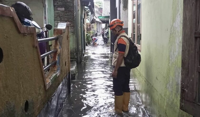 Personel BPBD Kota Malang pada saat melakukan asesmen pada salah satu titik banjir yang disebabkan hujan dengan intensitas tinggi di wilayah Kota Malang, Jawa Timur, Jumat (24/3/2023). Foto: Antara