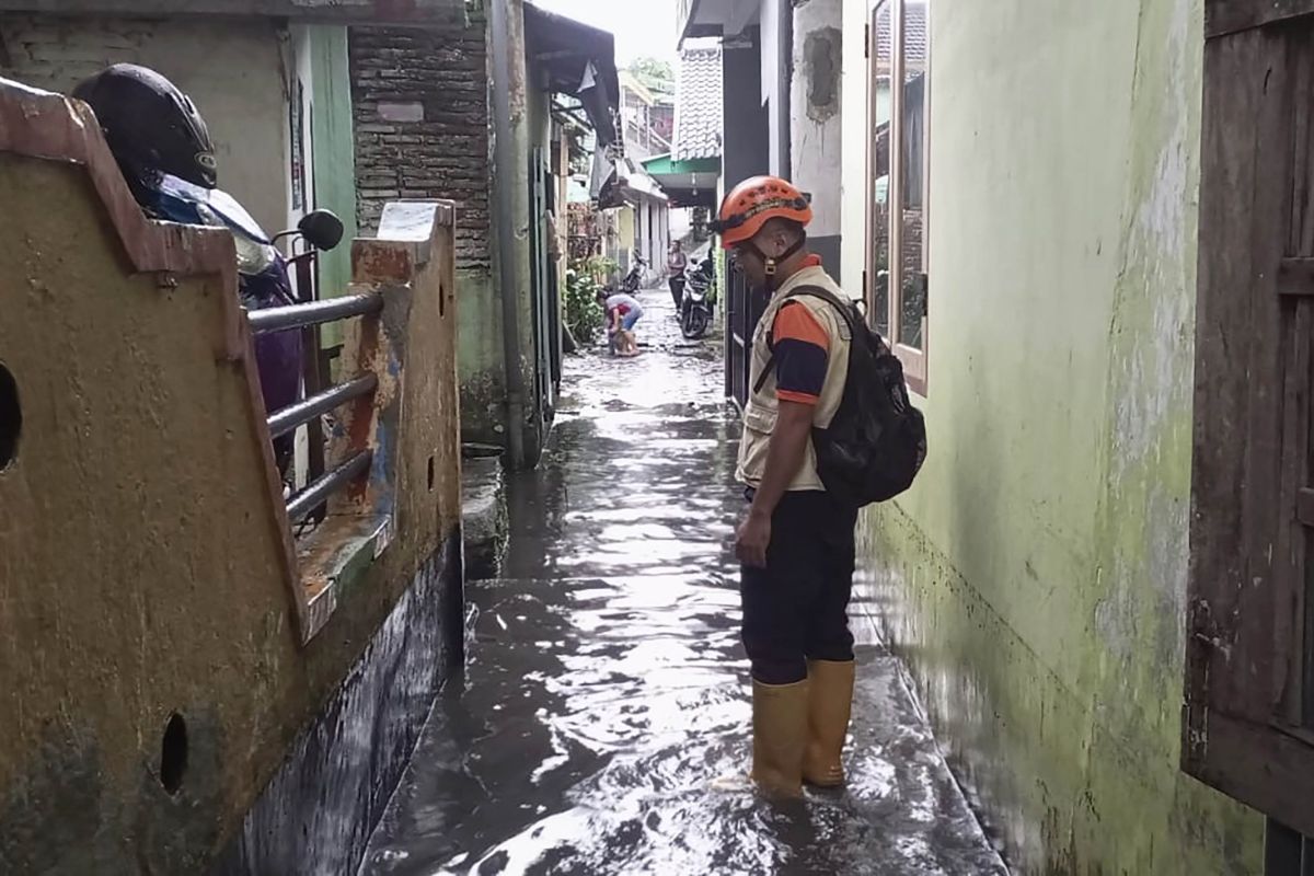 Personel BPBD Kota Malang pada saat melakukan asesmen pada salah satu titik banjir yang disebabkan hujan dengan intensitas tinggi di wilayah Kota Malang, Jawa Timur, Jumat (24/3/2023). Foto: Antara