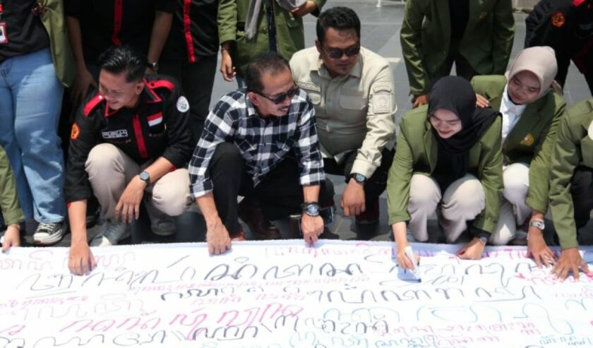 Wakil Ketua DPRD Kota Surabaya AH Thony bersama mahasiswa UPN Veteran Jatim menuliskan aksara Jawa pada kain putih yang dibentangkan di Balai Pemuda Surabaya, Selasa (31/10/2023), dalam upaya pelestarian budaya Jawa. Foto : Antara