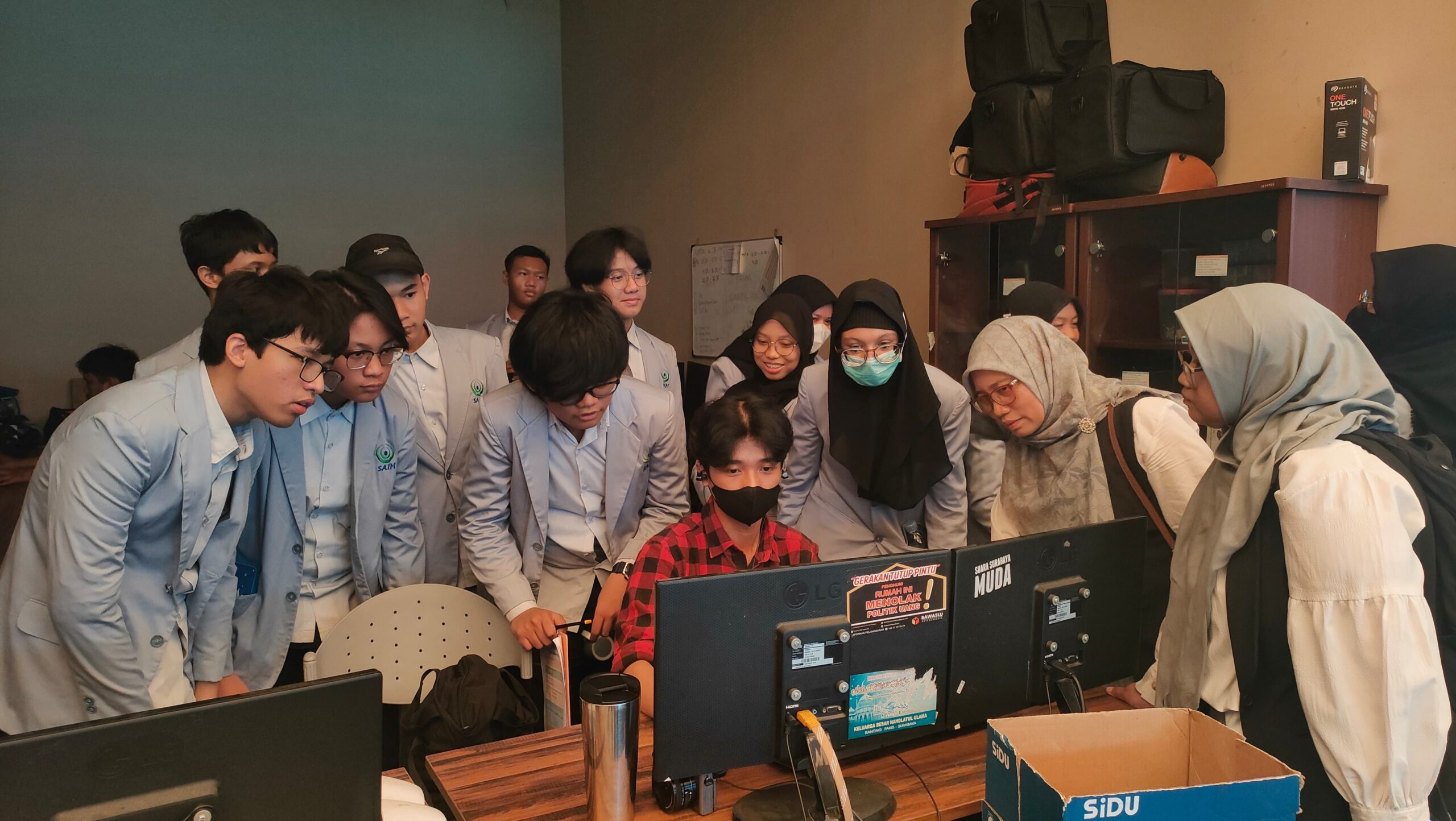 Siswa siswi SMP SAIM Surabaya melihat proses pengerjaan desain konten di ruang grafis suara Surabaya, Senin (6/11/2023). Foto: Feby Magang suarasurabaya.net 