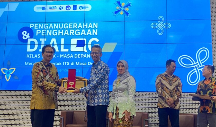 Prof Mochamad Ashari Rektor ITS menyerahkan penghargaan media partner terbaik pada Verry Firmansyah CEO Suara Surabaya, Sabtu (11/11/2023). Foto: Meilita suarasurabaya.net