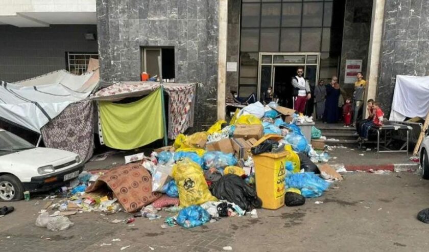 Tumpukan sampah di antara tenda pengungsi di halaman rumah sakit Al Shifa selama operasi darat Israel di sekitar rumah sakit, di Kota Gaza (12/11/2023). Foto: Reuters