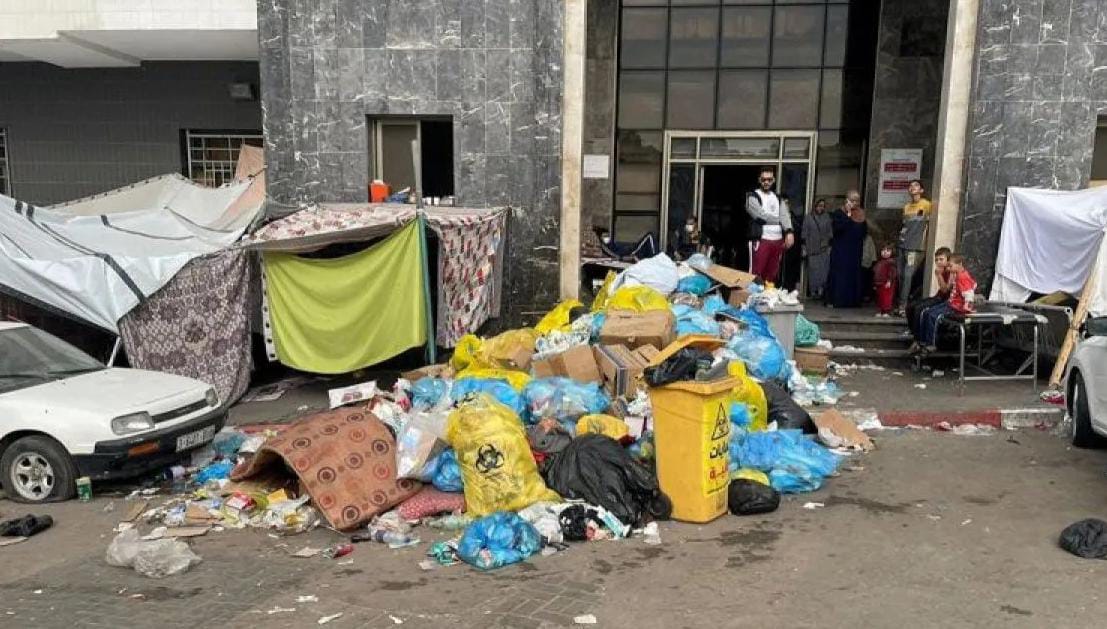 Tumpukan sampah di antara tenda pengungsi di halaman rumah sakit Al Shifa selama operasi darat Israel di sekitar rumah sakit, di Kota Gaza (12/11/2023). Foto: Reuters