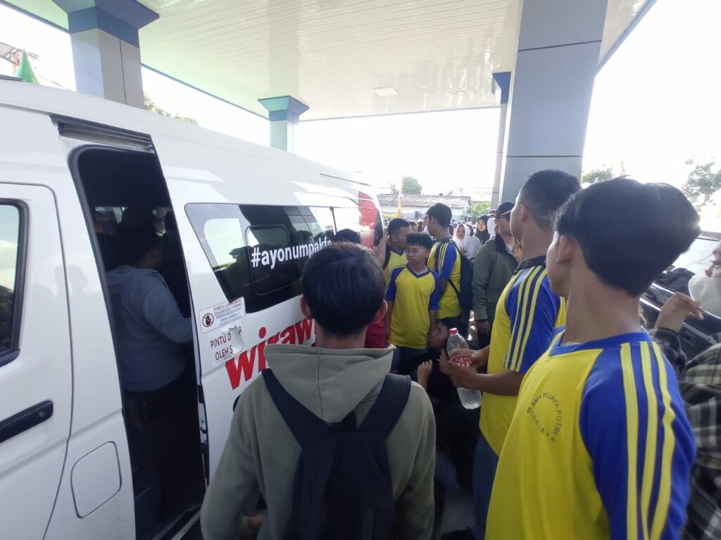 Para pelajar saat antre masuk angkutan feeder di terminal Benowo untuk menuju Stadion Gelora Bung Tomo (GBT) Surabaya, pada Selasa (21/11/2023). Foto: Risky suarasurabaya.net