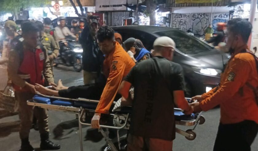 Petugas mengevakuasi perempuan asal Jakarta yang menabrakkan mobilnya ke pembatas Jalan Praban, Kota Surabaya, Jumat (24/11/2023). Perempuan ini diduga dalam pengaruh minuman beralkohol. Foto: Command Center Kota Surabaya