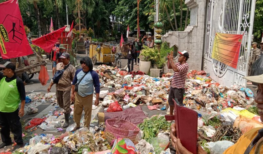 Massa aksi membuang tumpukan sampah di depan Pendopo Kapupaten Sidoarjo, Rabu (21/12/2023) kemarin. Foto: Istimewa