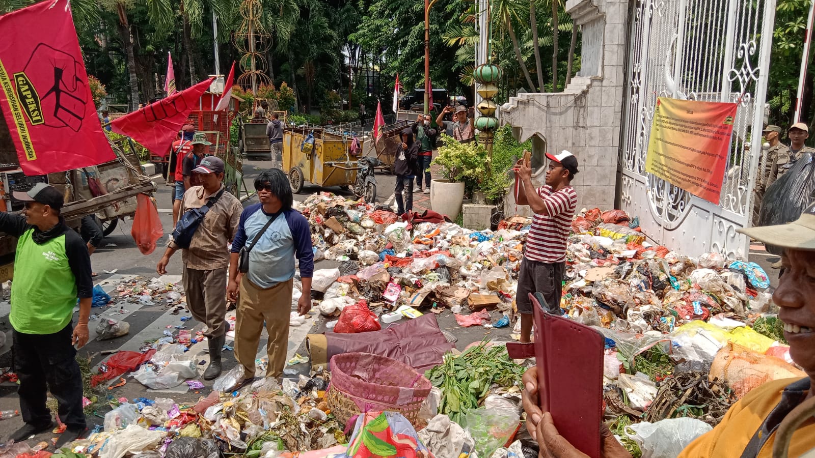 Massa aksi membuang tumpukan sampah di depan Pendopo Kapupaten Sidoarjo, Rabu (21/12/2023) kemarin. Foto: Istimewa