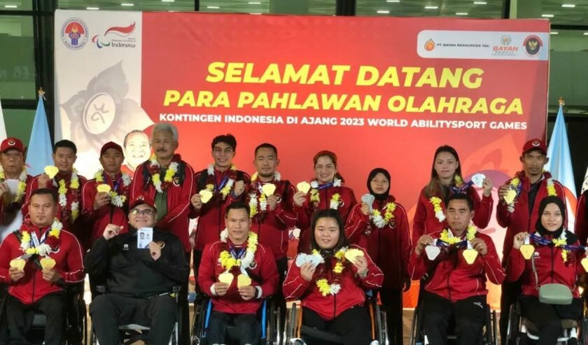 (jaket hitam) Ardima Rama Putra Chef de Mission (CdM) kontingen Indonesia berpose bersama kontingen para atlet Indonesia setibanya di Terminal 3 Bandara Internasional Soekarno-Hatta, Tangerang, Banten, Sabtu (9/12/2023) malam. Foto: Antara