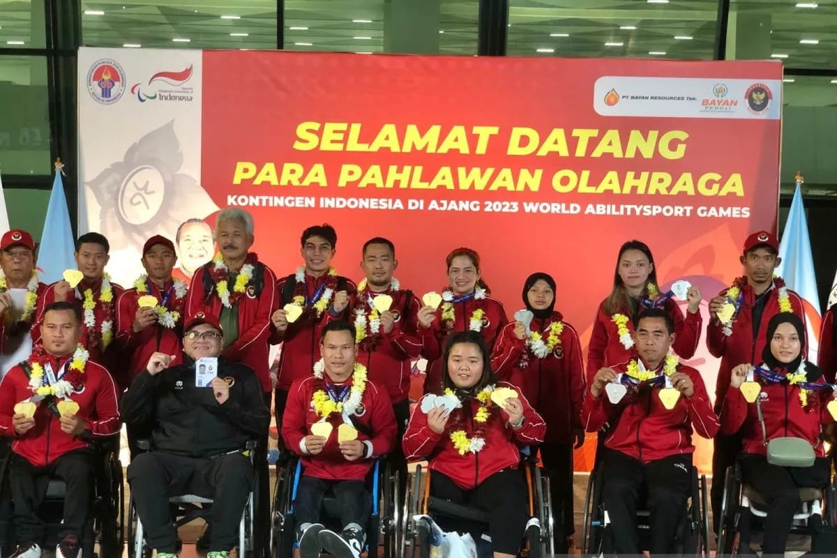 (jaket hitam) Ardima Rama Putra Chef de Mission (CdM) kontingen Indonesia berpose bersama kontingen para atlet Indonesia setibanya di Terminal 3 Bandara Internasional Soekarno-Hatta, Tangerang, Banten, Sabtu (9/12/2023) malam. Foto: Antara