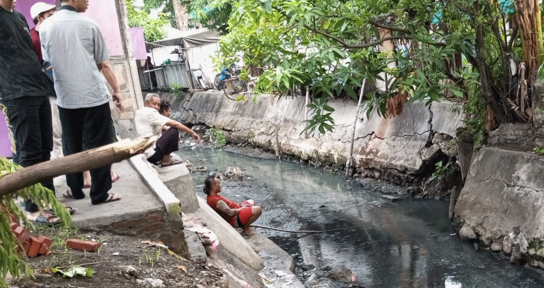 Warga Pacar Kembang, Surabaya menunggu di depan lubang gorong-gorong tempat pelaku jambret bersembunyi, Senin (11/12/2023). Foto: Command Center Surabaya