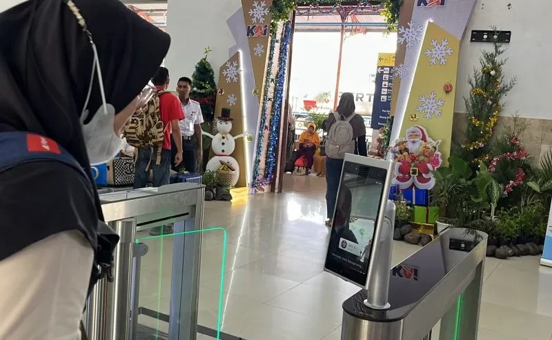 Pelanggan KAI mengggunakan layanan face recognition boarding gate atau pengenalan wajah saat boarding di Stasiun Madiun, Selasa (26/12/2023). Foto: Antara