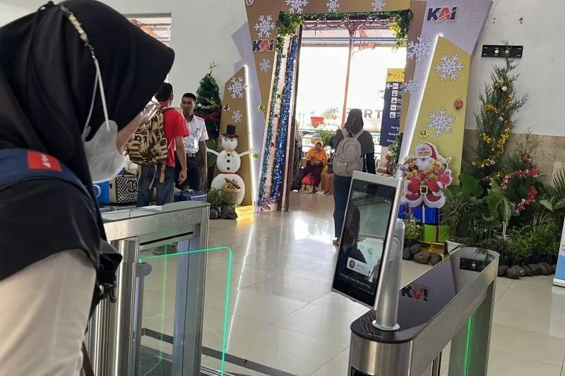 Pelanggan KAI mengggunakan layanan face recognition boarding gate atau pengenalan wajah saat boarding di Stasiun Madiun, Selasa (26/12/2023). Foto: Antara