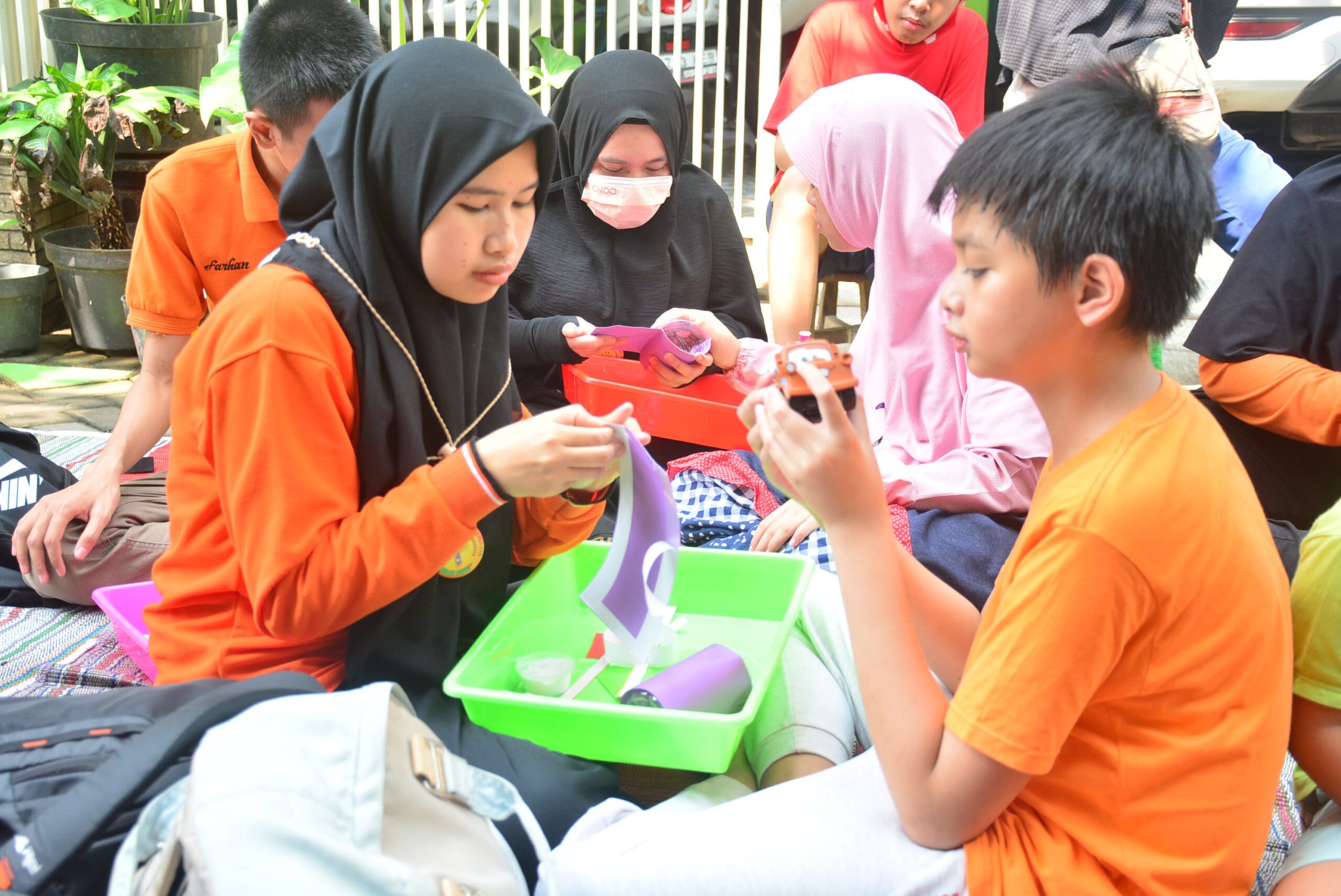 Anak berkebutuhan khusus PKBM Lentera Fajar Indonesia membuat kerajinan tangan di Kampung Edukasi Sampah Sidoarjo, Sabtu (16/12/2023). Foto: PKBM Lentera Fajar Indonesia