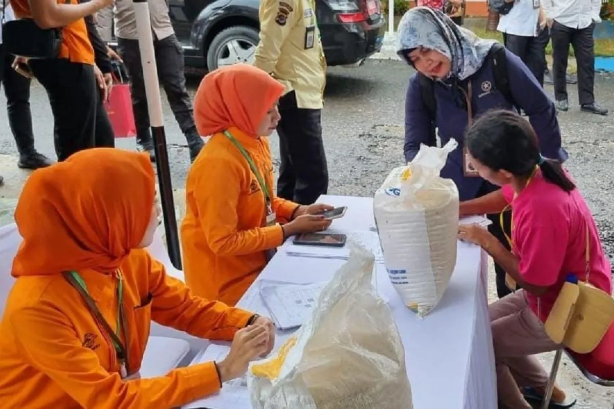 Warga penerima bantuan pangan (PBP) menerima penyaluran bantuan cadangan beras pemerintah (CBP) melalui kantor pos. Foto: Antara