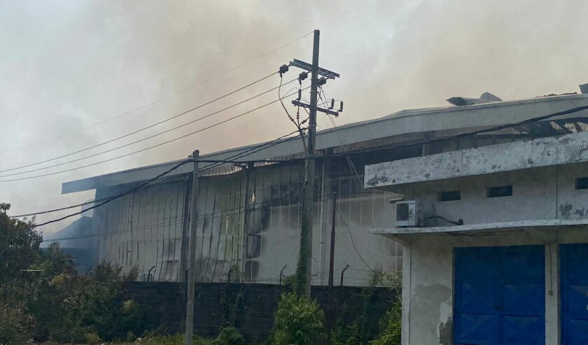 Kepulan asap masih membubung tinggi hingga Jumat pagi di gudang penyimpanan di Jalan Raya Sadang, Kecamatan Taman, Sidoarjo, Jumat (8/12/2023). Foto: Wildan suarasurabaya.net