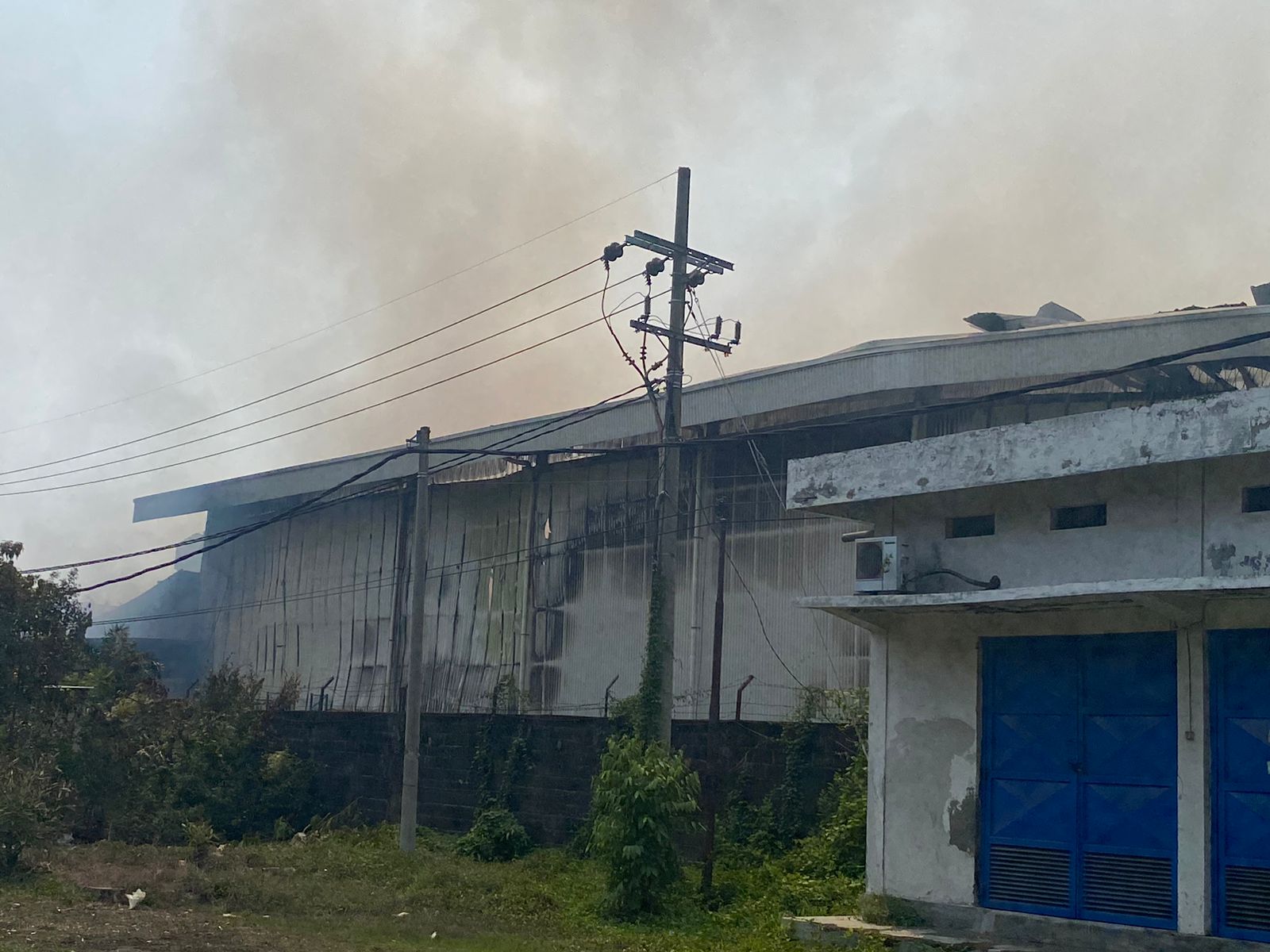 Kepulan asap masih membubung tinggi hingga Jumat pagi di gudang penyimpanan di Jalan Raya Sadang, Kecamatan Taman, Sidoarjo, Jumat (8/12/2023). Foto: Wildan suarasurabaya.net