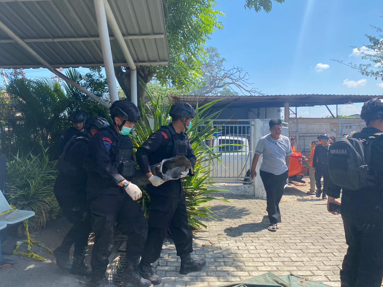 Tim gegana mengamankan salah satu selongsong yang ditemukan di area gedung KAI di Jalan Kamal, Bangkalan, Madura, Jumat (29/12/2023). Foto: Wildan suarasurabaya.net