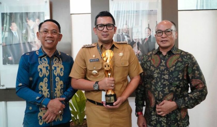 M Ali Kuncoro (tengah) Pj Wali Kota Mojokerto memegang penghargaan bergengsi dengan predikat sebagai Kota Terinovatif dalam Inovative Government Award (IGA) tahun 2023, Selasa (12/12/2023). Foto: Pemkot Mojokerto