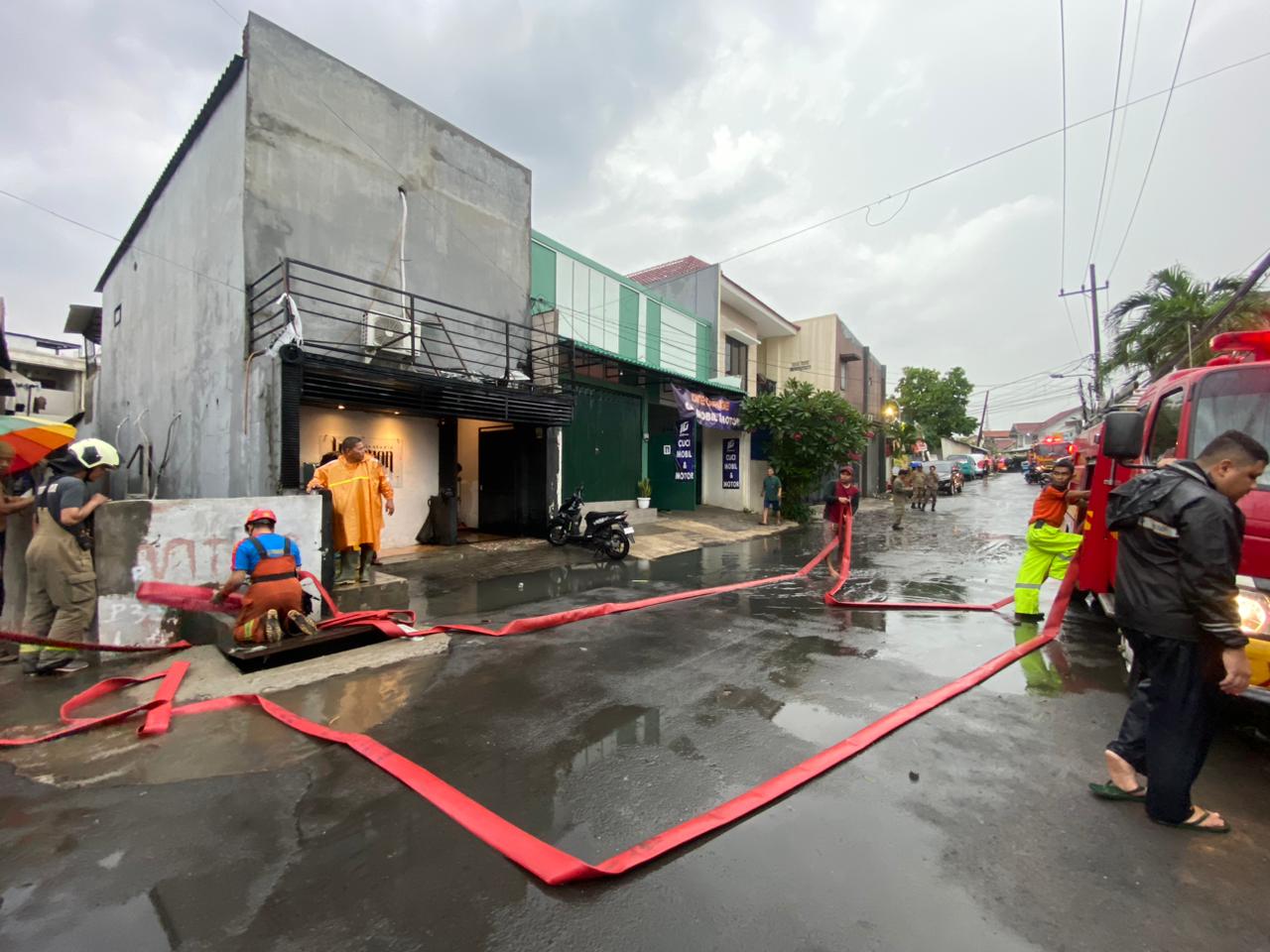 Petugas DPKP menyedot air sungai dari sisi kiri ke kanan, agar tak lagi meluap di Jalan Dukuh Kupang Barat I Surabaya, Selasa (9/1/2024). Foto: Meilita suarasurabaya.net